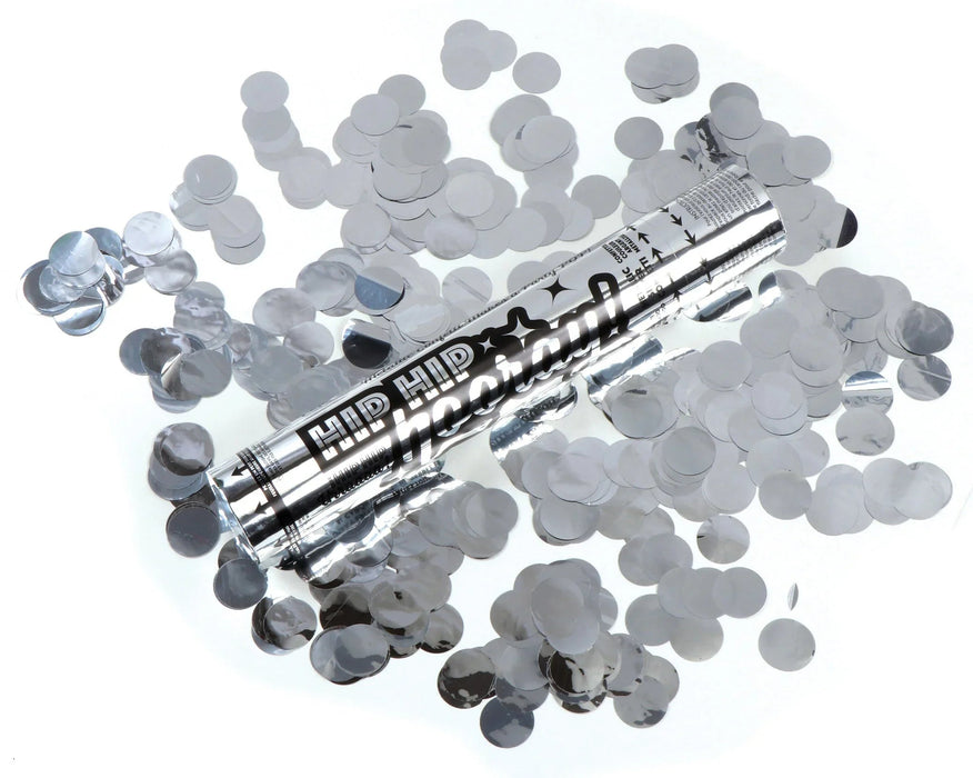 Silver metallic confetti cannon with black text and star designs, surrounded by scattered clear and silver confetti pieces on a white background.