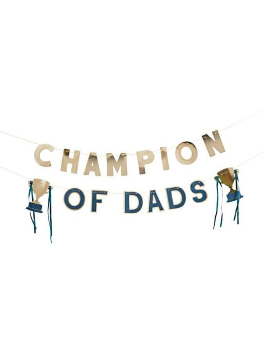 Gold and navy letter banner reading "CHAMPION OF DADS" with two small gold trophy cups hanging from teal ribbons on either side.