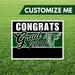 Graduation-themed customizable sign with 'Congrats Grad 2026' on a grass background