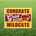 Yellow and maroon yard sign with "CONGRATS Grad 2026 WILDCATS" text and a wildcat head logo on green grass background.