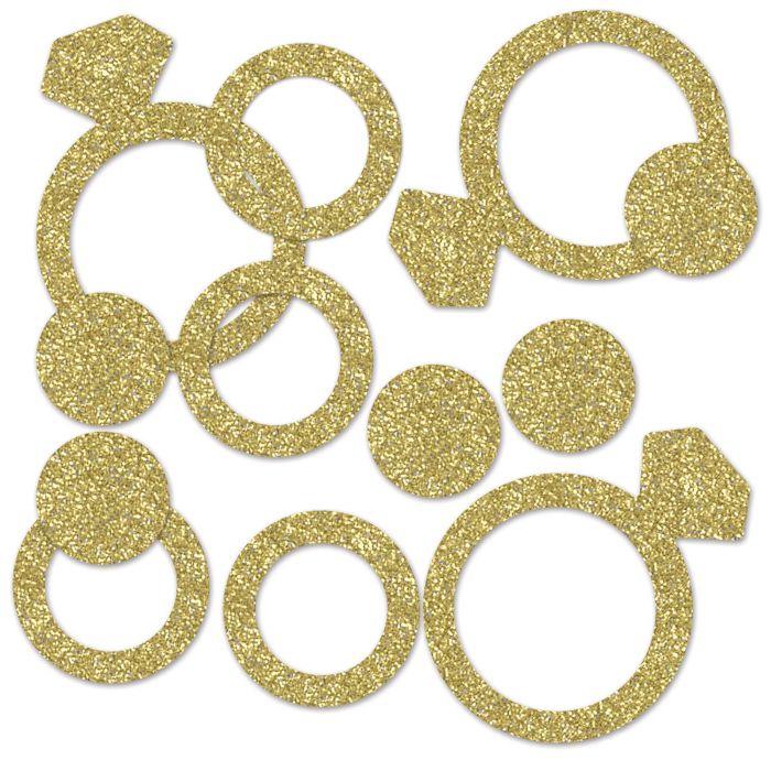Gold glitter diamond ring and circle shaped confetti pieces arranged on a white background.
