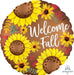 Round brown satin balloon decorated with bright yellow sunflowers, smaller yellow flowers, and colorful berries on a brown background with white "Welcome Fall" text.