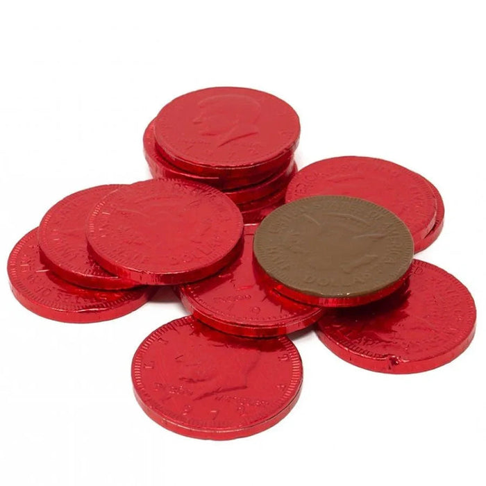 Red foil-wrapped chocolate coins scattered in a pile with one brown coin visible among them.