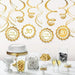 Gold spiral streamers and four starburst medallions labeled "Happy 30th Birthday" hang above a white table displaying champagne flutes, pearl and gold beaded centerpieces, and a cake stand with gold trim.