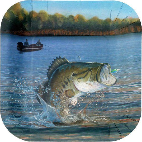 Fishing party setup with bass plates and cups, green napkins, fish garland, bobbers, fishing lures, rods, rocks, greenery, blue paper shred, and outdoor tackle-themed decor.