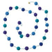 Long beaded garland with blue, teal, and purple pompoms connected by thin strands, arranged in a decorative loop.