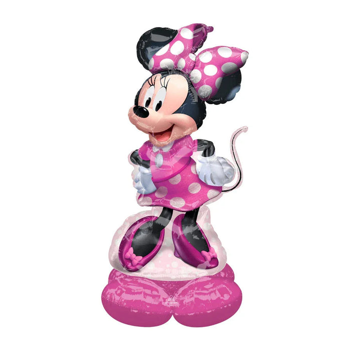 Uninflated foil balloon featuring Minnie Mouse in a pink polka-dot dress with a large pink bow, white gloves, and pink shoes, standing on a pink base.