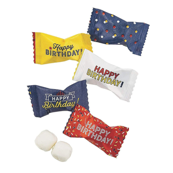 Six colorful wrapped butter mint candies in yellow, white, navy blue with polka dots, navy blue with banner design, and red with confetti patterns, each printed with "Happy Birthday" text, arranged with two unwrapped white mints below.