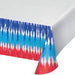 Patriotic tie-dye paper tablecloth with red, white, and blue vertical striped pattern draped on a corner of a white table.