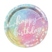 Round iridescent paper plate with pastel gradient from blue, pink, and yellow, featuring white "happy birthday" text and stars, shown as a single plate.