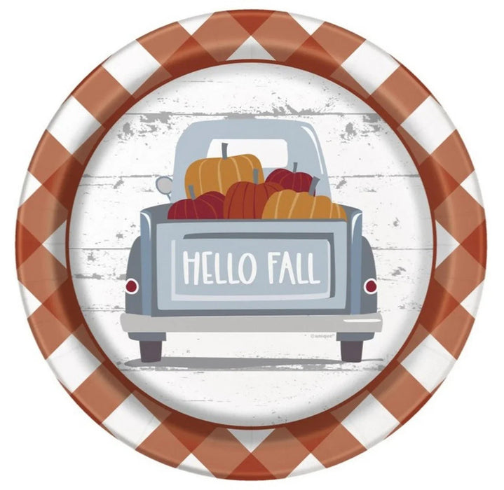 Round paper plate with rust and white gingham border featuring an illustration of a vintage truck loaded with pumpkins and "Hello Fall" text on white shiplap background.