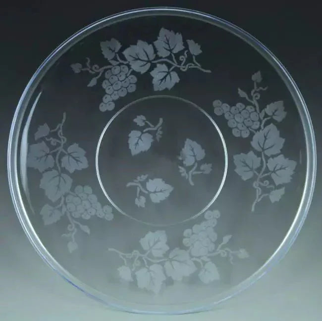 Clear glass serving platter with etched grapevine and leaf design around the outer ring and smaller vine motif in the center well.