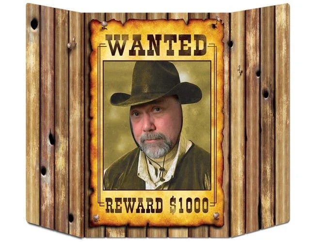 Cardboard Western wanted poster prop with wood grain background, featuring a man in a cowboy hat and tan shirt in the center frame, with "WANTED" text at top and "REWARD $1000" at bottom.