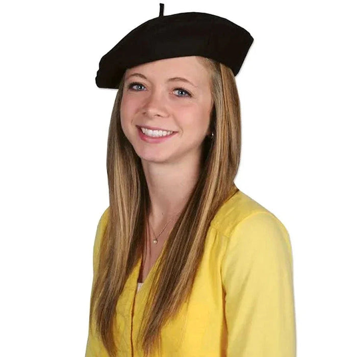 Black wool beret hat displayed on a model with long auburn hair wearing a yellow cardigan.