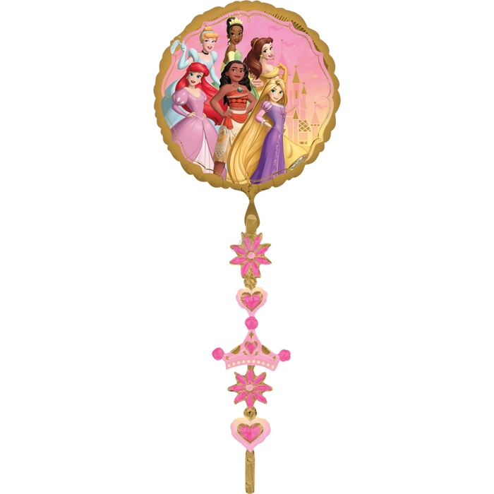 Gold foil balloon featuring six Disney Princesses in colorful dresses against a pink background, with a dangling tail of pink stars, hearts, and a crown charm.