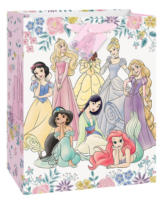 Pink gift bag featuring nine Disney Princesses in colorful ball gowns surrounded by a floral border design with roses and small flowers.