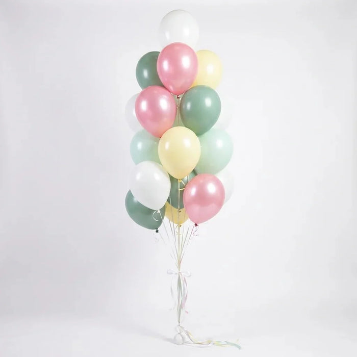 Balloon bouquet featuring pastel pearl pink, sage green, mint, pale yellow, and white latex balloons with curling ribbons.