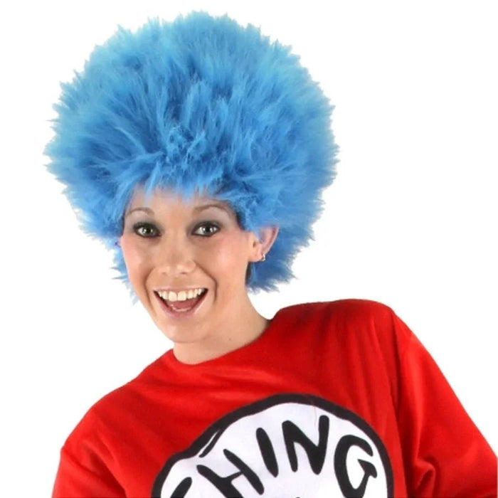 Bright blue fluffy wig styled in a tall spiky bouffant with bangs, worn with a red shirt featuring a black and white circular logo.