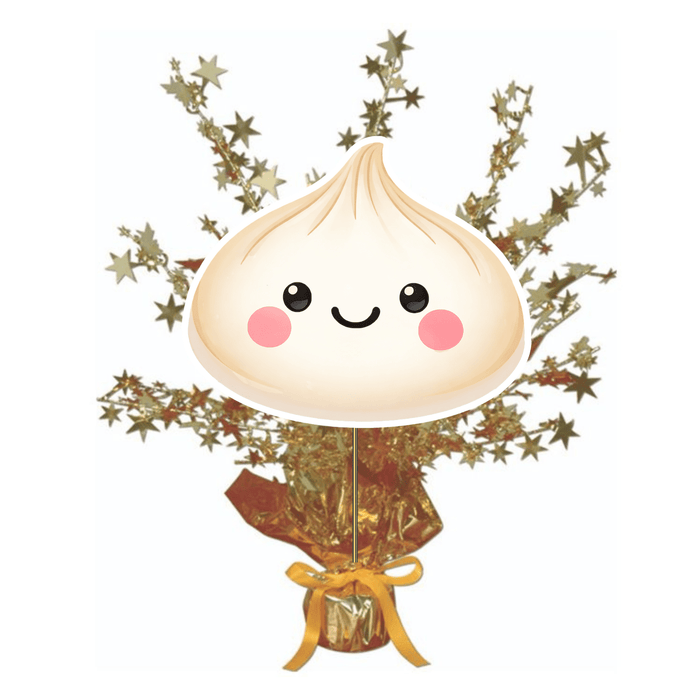 Dumpling-themed table centerpiece with a smiling dumpling cutout on a stick, set in a gold foil base with metallic starburst sprays, displayed against a white background.