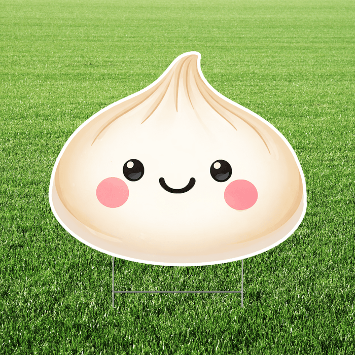 Large dumpling-shaped yard sign with a smiling face and pink cheeks, displayed on a lawn with an H stake stand.