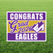 Purple and gold yard sign with white text reading "CONGRATS Grad 2026 EAGLES" and a checkmark graphic on green grass.