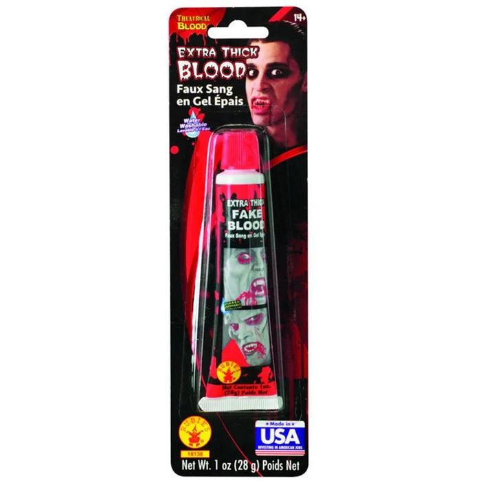 Red tube of Extra Thick Fake Blood gel in a 1 oz size with a bright pink cap, displayed on black and red theatrical packaging made in the USA.