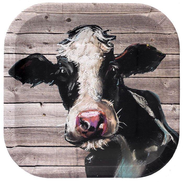 Square melamine plates with rustic wood grain background and whimsical painted black and white cow face design with pink nose.