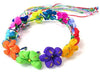 Colorful flower crown halo featuring fabric blooms in pink, purple, green, orange, yellow, and blue shades with braided rainbow ribbons attached.