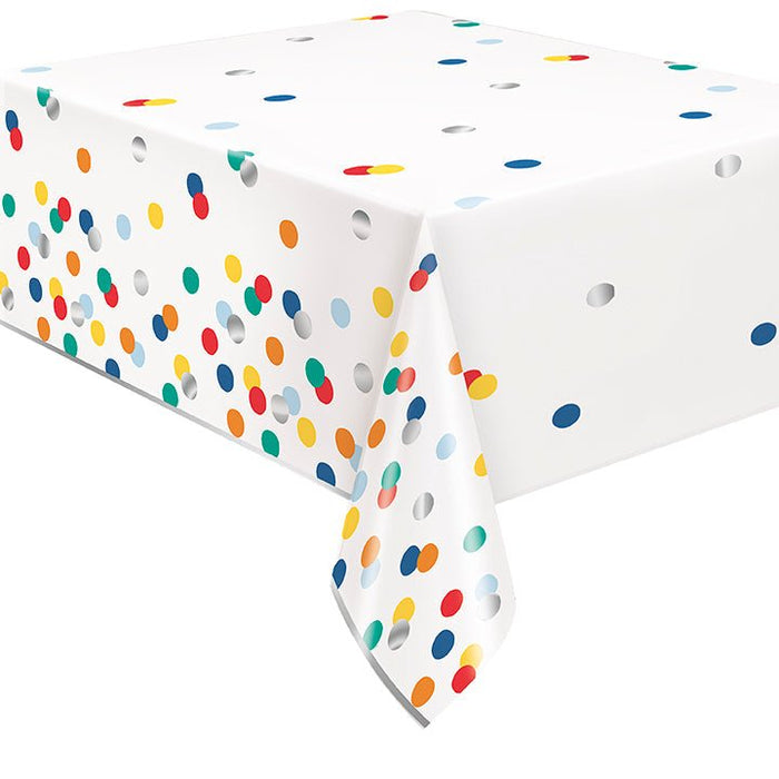 White plastic tablecloth with colorful polka dots in red, yellow, orange, blue, green, and gray scattered across the surface.
