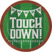 Round paper plate with brown football texture border, green grass field center, white "TOUCH DOWN!" text, yard line markings, and bunting banner with score numbers 50, 40, 30, 20, 10 displayed across top.
