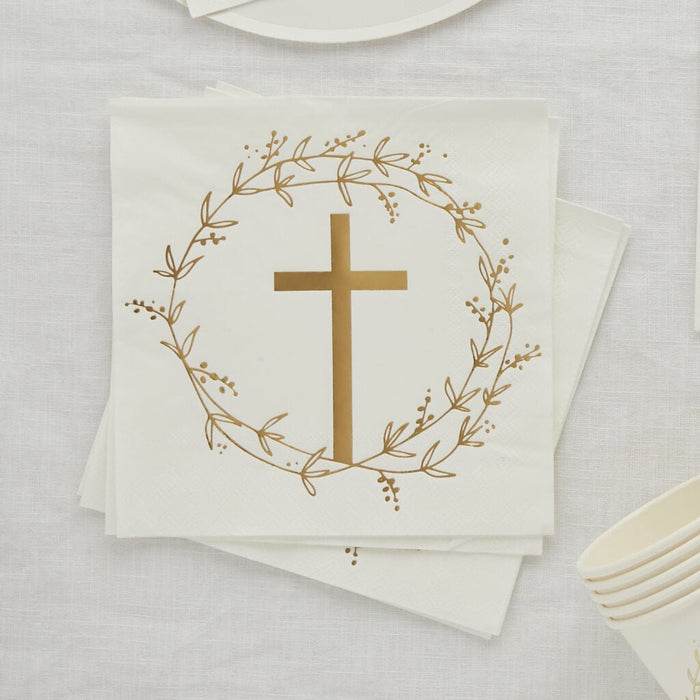 Stack of cream-colored paper napkins featuring a gold cross centered within a delicate botanical wreath design.