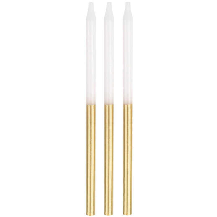 Set of three tall taper candles with white bodies and gold-dipped lower portions against a white background.