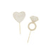 Two gold-colored wooden cake toppers on white background: a heart-shaped pick labeled "Engaged" and a diamond ring-shaped pick with geometric line detailing.