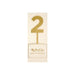 Gold number 2 acrylic cake topper with a stake base on cream-colored cardstock packaging labeled "My Mind's Eye paper goods acrylic number.