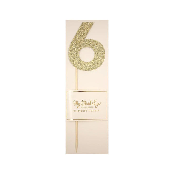 Gold glitter number 6 cake topper on a wooden stick with cream packaging labeled "My Mind's Eye Glittered Number.