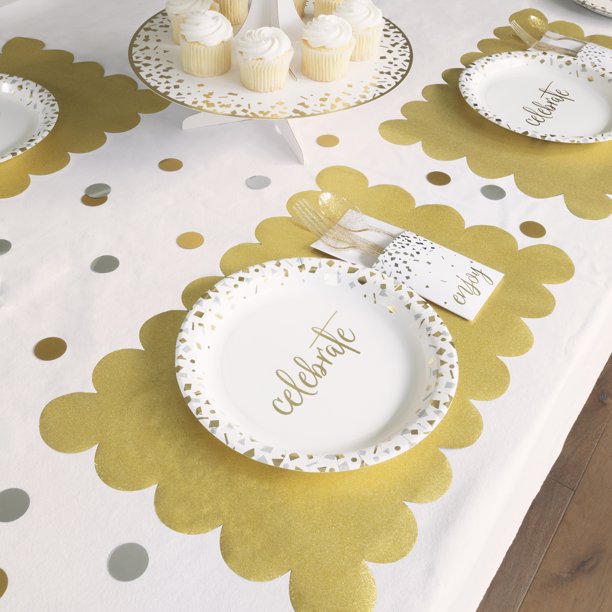 Gold glitter scalloped placemats shown under white celebration plates with gold confetti accents on a party table.