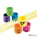 Six colorful coiled spring toys with smiling face designs in green, purple, blue, yellow, orange, and pink, displayed with yellow spring coils on white background.