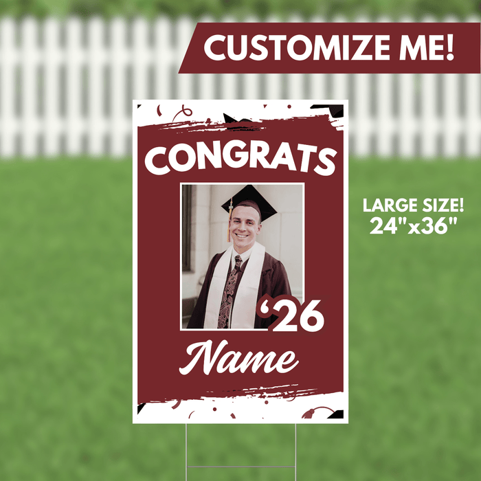 Burgundy and white yard sign with "CONGRATS" text, a photo frame showing a graduate in cap and gown, the year "'26," and customizable name area, measuring 24 inches by 36 inches.