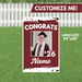 Burgundy and white yard sign with "CONGRATS" text, a photo frame showing a graduate in cap and gown, the year "'26," and customizable name area, measuring 24 inches by 36 inches.