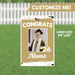 Gold and white graduation yard sign 24 by 36 inches featuring a customizable photo frame with "CONGRATS," the year 26, and a name placeholder, displayed against a white picket fence and green grass background.