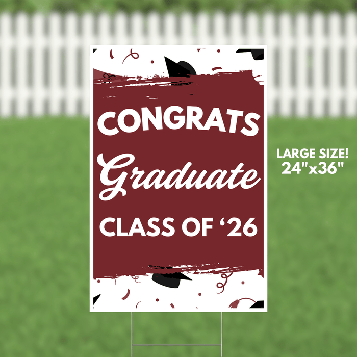 Burgundy and white yard sign with "CONGRATS Graduate CLASS OF '26" text, black graduation cap illustrations, and confetti design, measuring 24 by 36 inches.