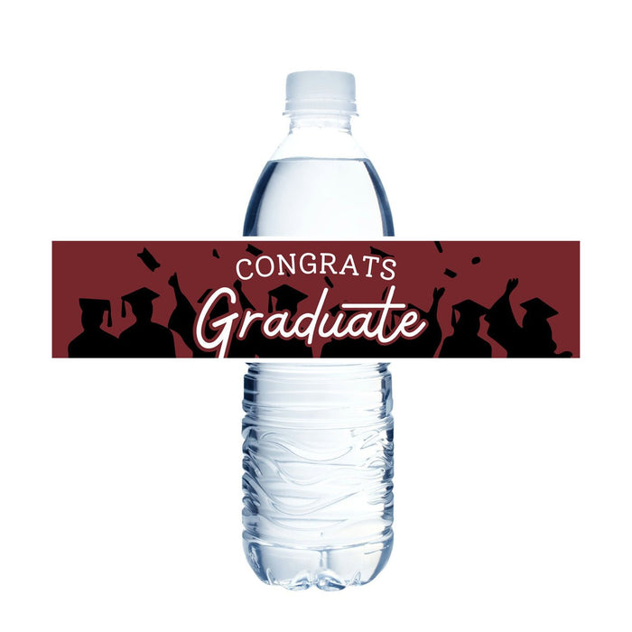 Clear plastic water bottle with a maroon and black "Congrats Graduate" label wrapped around the middle, featuring silhouettes of graduates in caps and gowns.