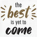 White napkin with tan and black text reading "the best is yet to come" with decorative radiating lines around the word "best".