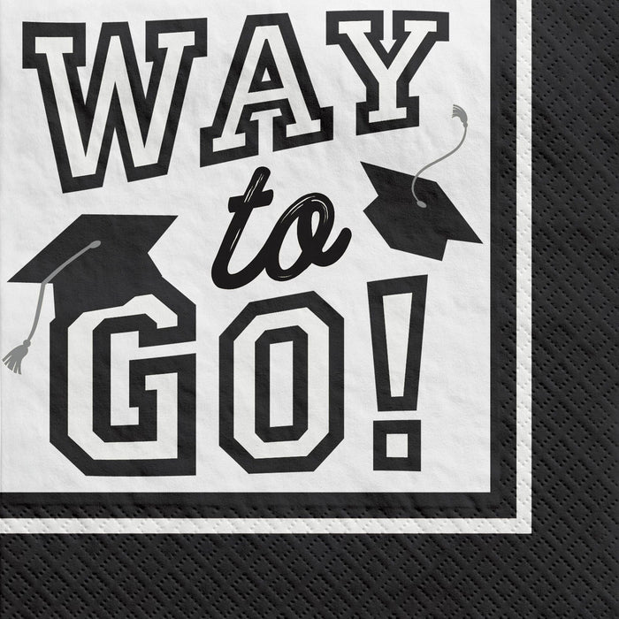 White beverage napkin with black text reading "Way to Go" and two black graduation caps with tassels in the corners.