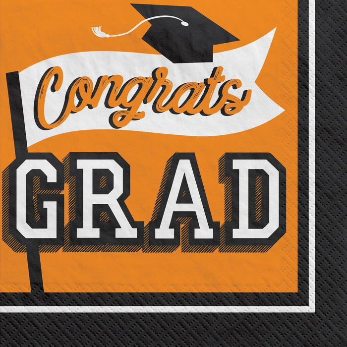 Orange and black graduation-themed luncheon napkins featuring a mortarboard cap and banner with "Congrats GRAD" text in white and orange lettering.