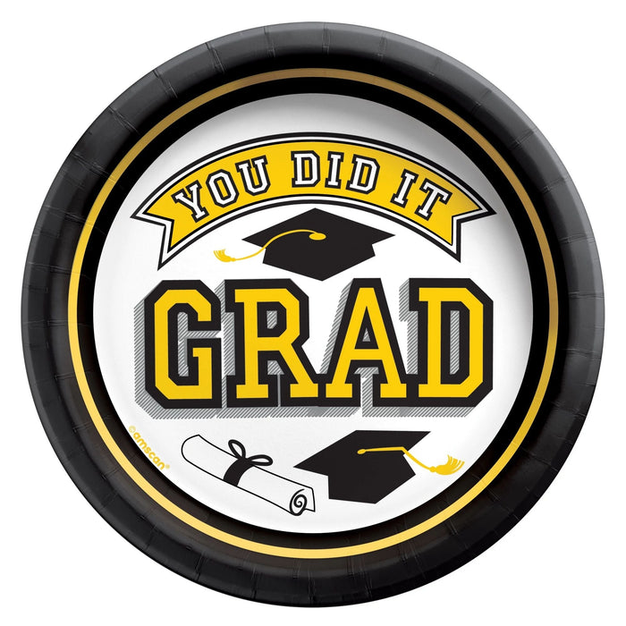 Black and gold bordered round paper plates with white center featuring yellow "GRAD" text, graduation caps, and diploma illustrations with "You Did It" banner text.