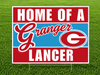 Home of a Granger Lancer yard sign featuring bold red, white, and light blue school colors, large white "HOME OF A" and "LANCER" text, a script-style "Granger" across the center, and the Granger High School "G" logo on a corrugated plastic yard sign with an H-stake for outdoor display.