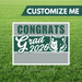Graduation-themed sign with 'Congrats Grad 2026' on a grass background