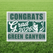 Green Canyon High School Class of 2026 graduation yard sign featuring a cougar mascot head in white on a dark green and gray striped background, displayed on grass.