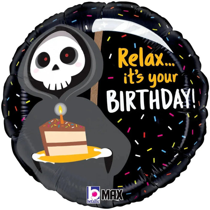 Round black mylar balloon featuring a skeleton character in a hooded robe holding a birthday cake, with "Relax... it's your BIRTHDAY!" text and colorful confetti design on black background.